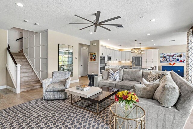 9657 Sterling Shores St, Delray Beach, FL 33446 - living area featuring ceiling fan, light wood finished floors, stairs, a textured ceiling, and recessed lighting