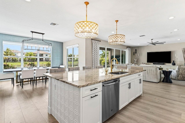 9657 Sterling Shores St, Delray Beach, FL 33446 - kitchen with stainless steel dishwasher, a sink, recessed lighting, a kitchen island with sink, and white cabinets