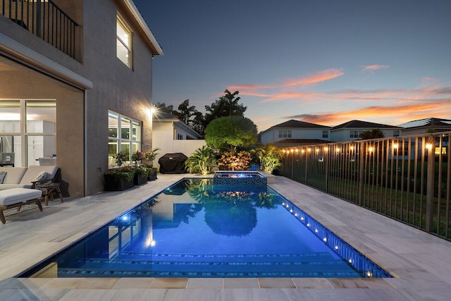9657 Sterling Shores St, Delray Beach, FL 33446 - pool at dusk featuring a fenced backyard, a patio, and a pool with connected hot tub