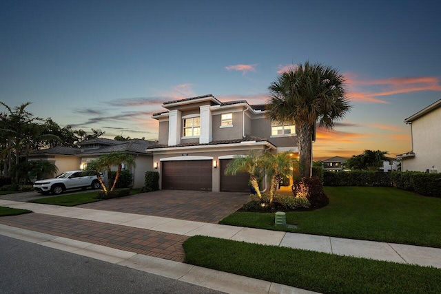 9657 Sterling Shores St, Delray Beach, FL 33446 - view of front facade featuring a garage, decorative driveway, a lawn, stucco siding, and a tile roof
