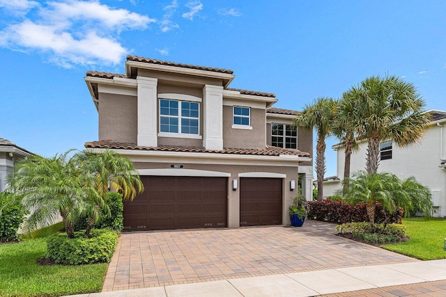 9657 Sterling Shores St, Delray Beach, FL 33446 - mediterranean / spanish-style house featuring an attached garage, a tiled roof, stucco siding, and decorative driveway