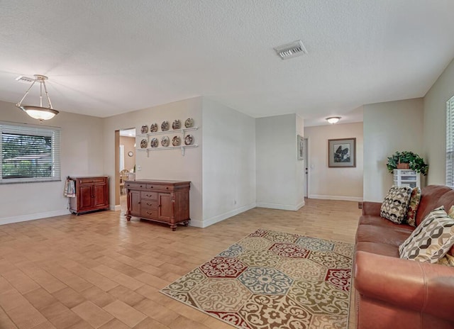 12275 N 54th St N, West Palm Beach, FL 33411 - living room featuring light wood-style floors, baseboards, and a textured ceiling