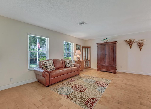 12275 N 54th St N, West Palm Beach, FL 33411 - living area with baseboards, light wood-type flooring, and a textured ceiling