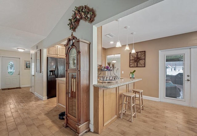 12275 N 54th St N, West Palm Beach, FL 33411 - kitchen with black refrigerator with ice dispenser, a breakfast bar, baseboards, and healthy amount of natural light