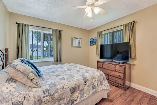 12275 N 54th St N, West Palm Beach, FL 33411 - bedroom featuring wood finished floors, baseboards, a ceiling fan, and a textured ceiling