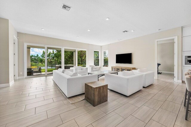 9258 Greenspire Ln, Lake Worth, FL 33467 - living room with healthy amount of natural light, baseboards, recessed lighting, and a textured ceiling
