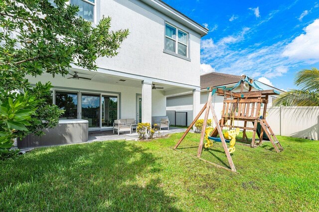 9258 Greenspire Ln, Lake Worth, FL 33467 - rear view of property with stucco siding, a playground, a patio, and a ceiling fan