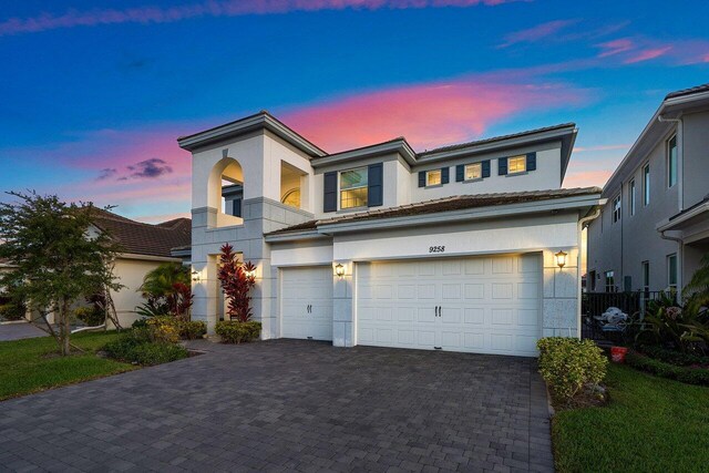 9258 Greenspire Ln, Lake Worth, FL 33467 - view of front facade with stucco siding, a garage, decorative driveway, and a balcony