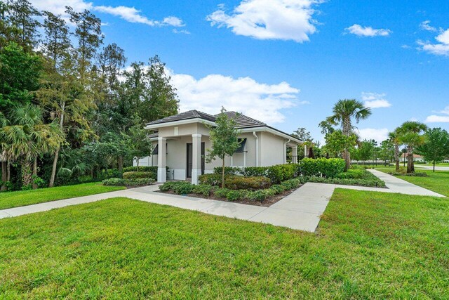 9258 Greenspire Ln, Lake Worth, FL 33467 - view of side of property featuring a lawn and stucco siding