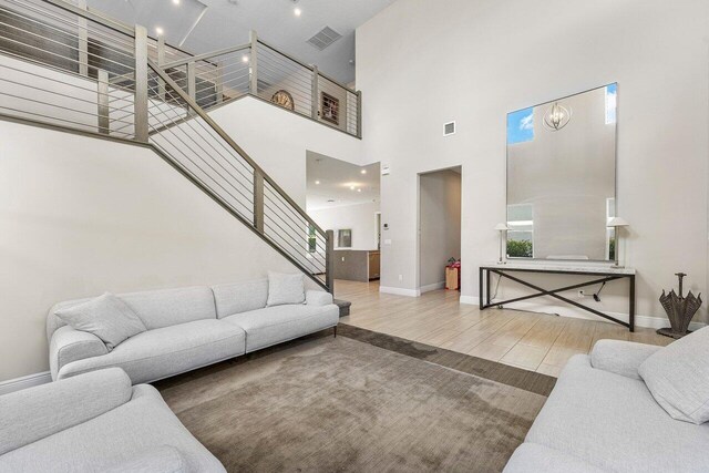 9258 Greenspire Ln, Lake Worth, FL 33467 - living area with stairs, wood finished floors, a high ceiling, and baseboards