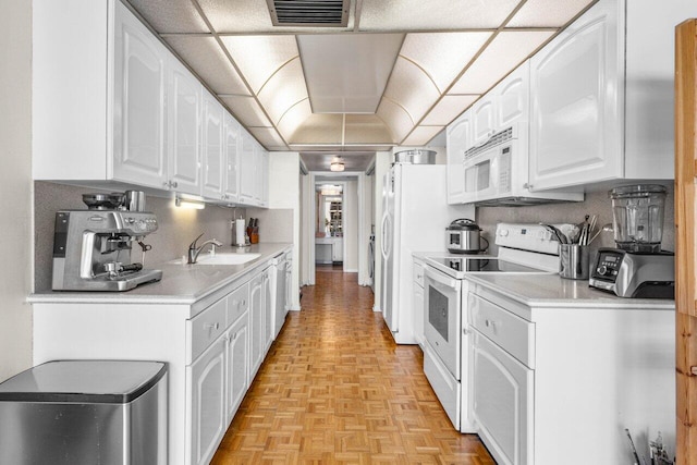 2001 N Ocean Blvd Unit 502, Boca Raton, FL 33431 - kitchen with white appliances, a sink, white cabinets, and light countertops