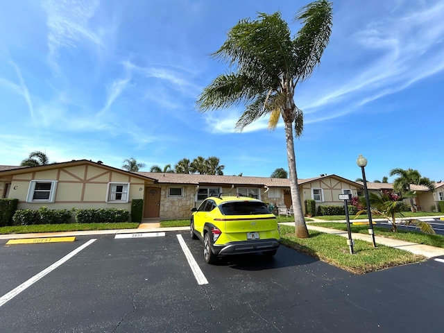 2802 Crosley Dr W Unit D, West Palm Beach, FL 33415 - view of front of home featuring uncovered parking, stone siding, a residential view, and stucco siding