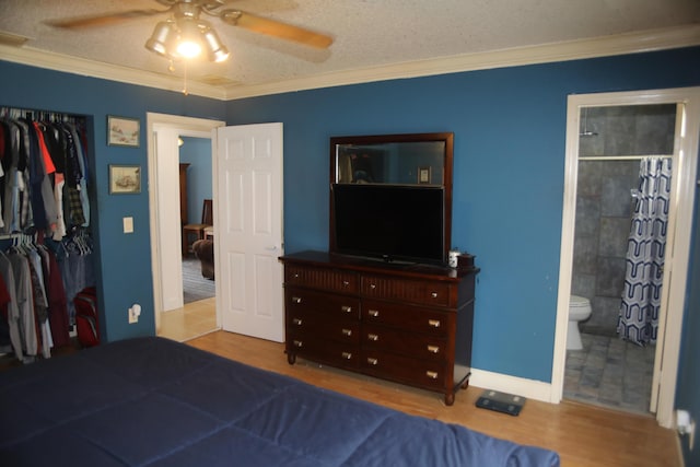 864 SE Tierra Ct, Port Saint Lucie, FL 34983 - bedroom with ornamental molding, a closet, wood finished floors, ensuite bathroom, and a textured ceiling