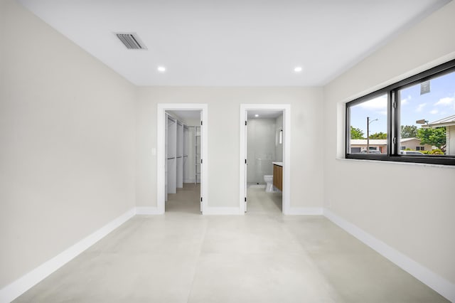 1182 SW 7th St, Boca Raton, FL 33486 - unfurnished bedroom with baseboards, a spacious closet, concrete flooring, recessed lighting, and ensuite bath