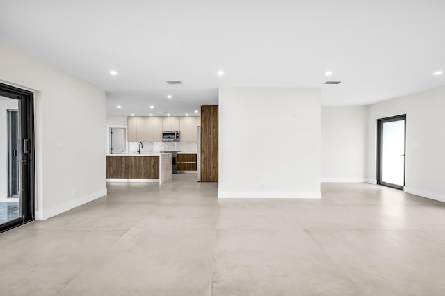 1182 SW 7th St, Boca Raton, FL 33486 - unfurnished living room with recessed lighting, baseboards, and concrete flooring