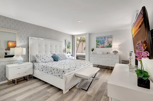 2701 N Ocean Blvd Unit E205, Boca Raton, FL 33431 - bedroom with wallpapered walls and light wood-style floors