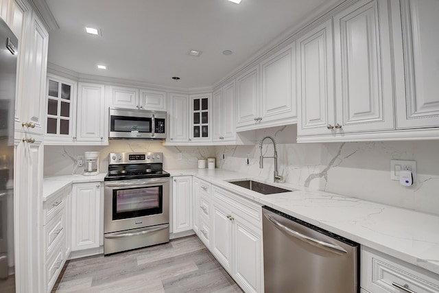 2701 N Ocean Blvd Unit E205, Boca Raton, FL 33431 - kitchen featuring stainless steel appliances, a sink, white cabinets, and glass insert cabinets