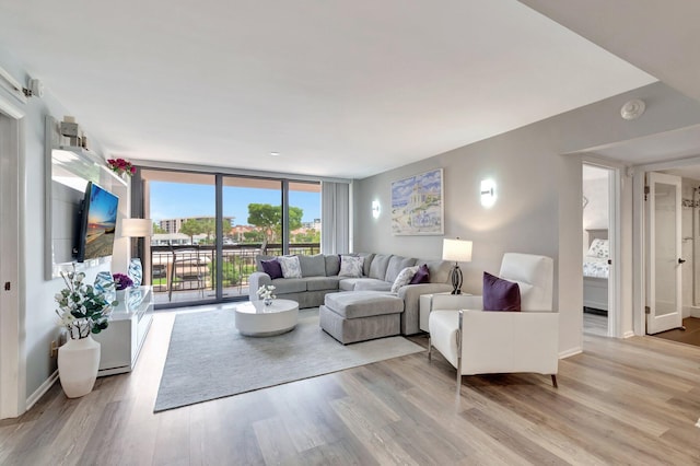 2701 N Ocean Blvd Unit E205, Boca Raton, FL 33431 - living room featuring light wood-style floors, floor to ceiling windows, and baseboards
