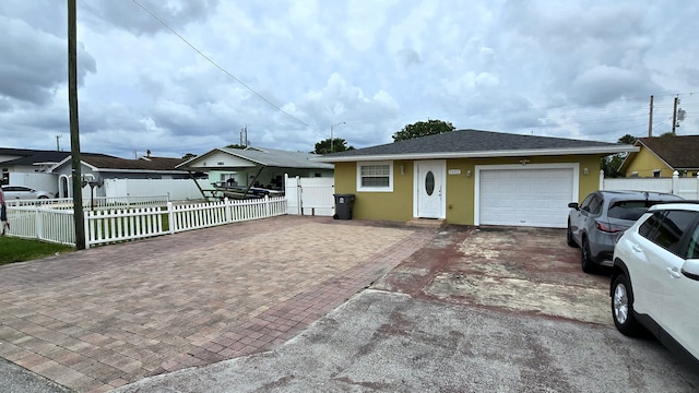 5692 Coconut Rd, West Palm Beach, FL 33413 - view of front facade with decorative driveway, an attached garage, stucco siding, and a shingled roof