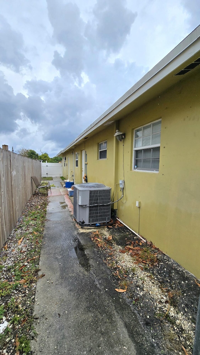 5692 Coconut Rd, West Palm Beach, FL 33413 - view of side of home with central AC, stucco siding, and a fenced backyard