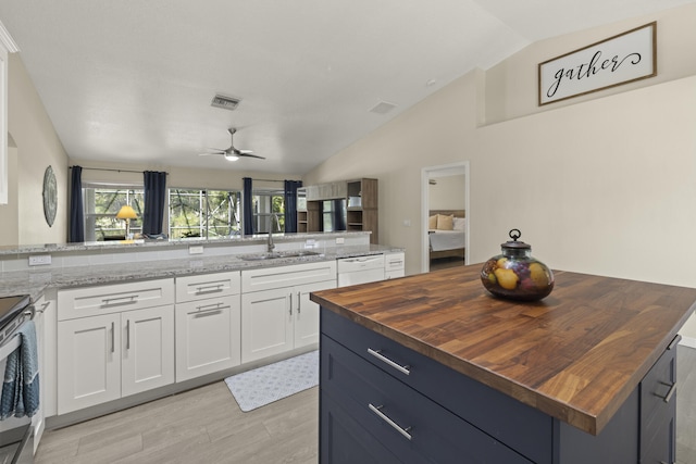 4312 SW Elaine Ct, Port Saint Lucie, FL 34953 - kitchen featuring a sink, wooden counters, white dishwasher, lofted ceiling, and light wood-type flooring