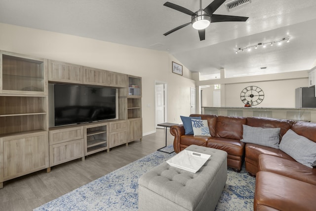4312 SW Elaine Ct, Port Saint Lucie, FL 34953 - living room with lofted ceiling, a ceiling fan, light wood-style floors, baseboards, and a textured ceiling