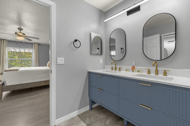 4312 SW Elaine Ct, Port Saint Lucie, FL 34953 - bathroom with connected bathroom, double vanity, a ceiling fan, and baseboards