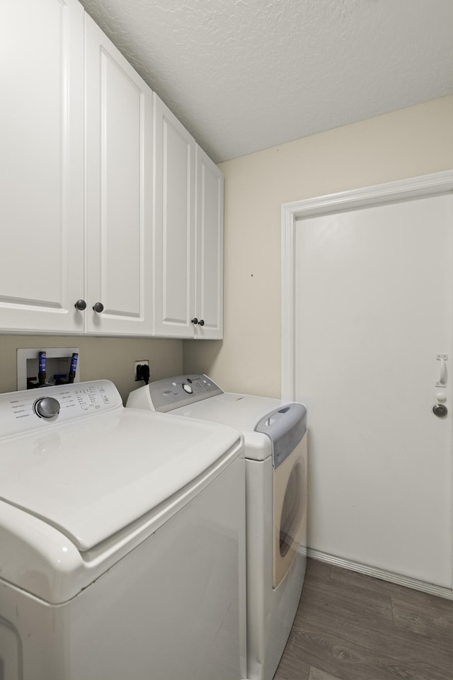 4312 SW Elaine Ct, Port Saint Lucie, FL 34953 - washroom featuring cabinet space, washer and clothes dryer, dark wood finished floors, and a textured ceiling