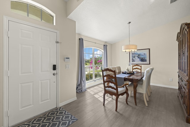 4312 SW Elaine Ct, Port Saint Lucie, FL 34953 - dining area with baseboards, dark wood-style flooring, lofted ceiling, a textured ceiling, and a chandelier