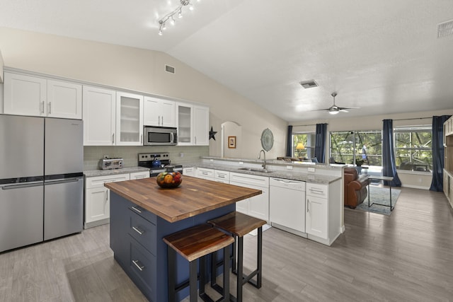 4312 SW Elaine Ct, Port Saint Lucie, FL 34953 - kitchen featuring appliances with stainless steel finishes, a peninsula, butcher block countertops, a sink, and open floor plan