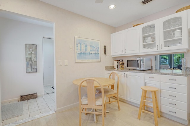 724 Nantucket Cir Unit A, Lake Worth, FL 33467 - kitchen featuring glass insert cabinets, white cabinetry, baseboards, recessed lighting, and light wood-type flooring