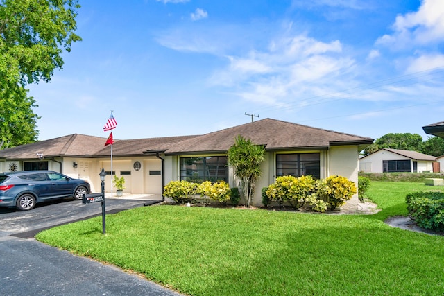 4858 Equestrian Rd Unit B, Boynton Beach, FL 33436 - view of front of home with stucco siding, a front lawn, driveway, and an attached garage