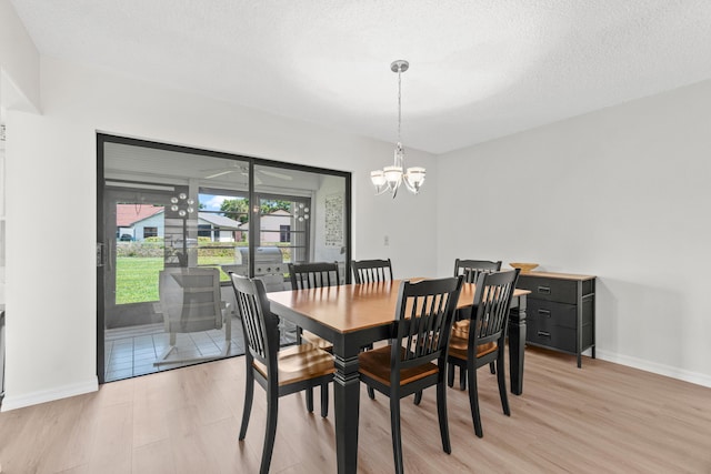 4858 Equestrian Rd Unit B, Boynton Beach, FL 33436 - dining area featuring light wood-type flooring, a chandelier, baseboards, and a textured ceiling