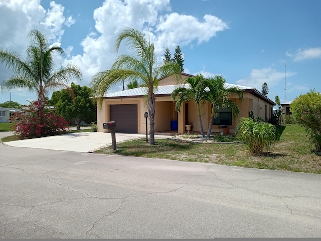 2 Antigua Ln, Port Saint Lucie, FL 34952 - view of front of property featuring driveway, stucco siding, an attached garage, and metal roof