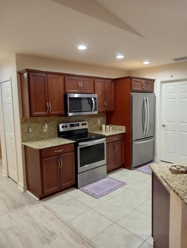 2 Antigua Ln, Port Saint Lucie, FL 34952 - kitchen with appliances with stainless steel finishes, tasteful backsplash, light stone countertops, recessed lighting, and light tile patterned floors