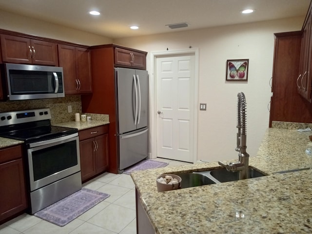 2 Antigua Ln, Port Saint Lucie, FL 34952 - kitchen featuring appliances with stainless steel finishes, light stone countertops, a sink, backsplash, and recessed lighting