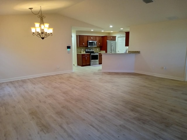 2 Antigua Ln, Port Saint Lucie, FL 34952 - unfurnished living room featuring a chandelier, light wood-style floors, recessed lighting, baseboards, and lofted ceiling