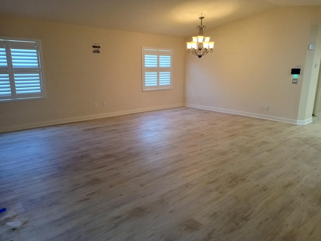 2 Antigua Ln, Port Saint Lucie, FL 34952 - unfurnished room featuring a chandelier, wood finished floors, baseboards, and lofted ceiling