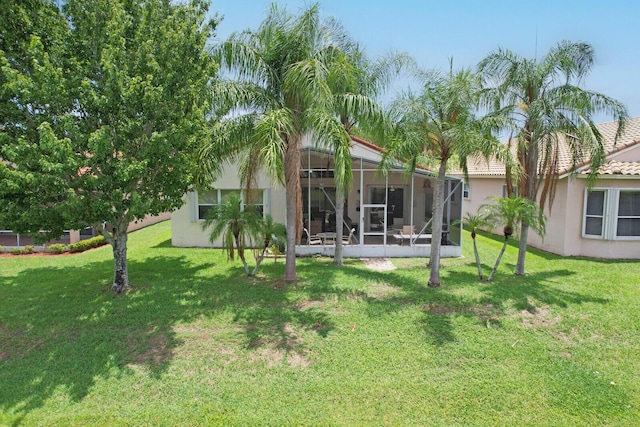 257 NW Toscane Trl, Port Saint Lucie, FL 34986 - rear view of house featuring a lawn, stucco siding, a sunroom, and a tiled roof