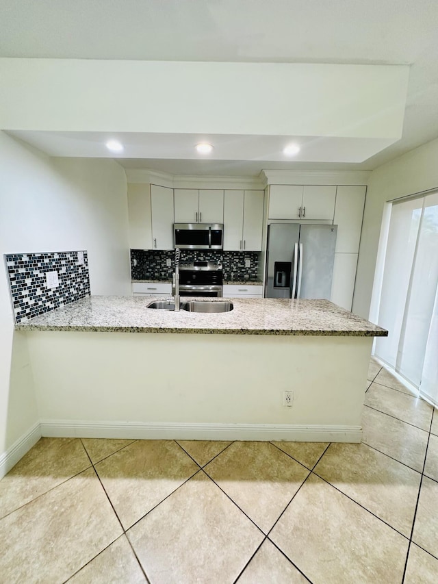 11887 SW 13th Ct, Davie, FL 33325 - kitchen featuring appliances with stainless steel finishes, a sink, decorative backsplash, light stone countertops, and recessed lighting