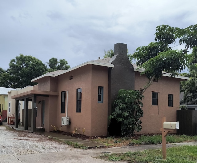 626 Texas Ct, Fort Pierce, FL 34950 - view of home's exterior featuring stucco siding, a cooling unit, and a chimney