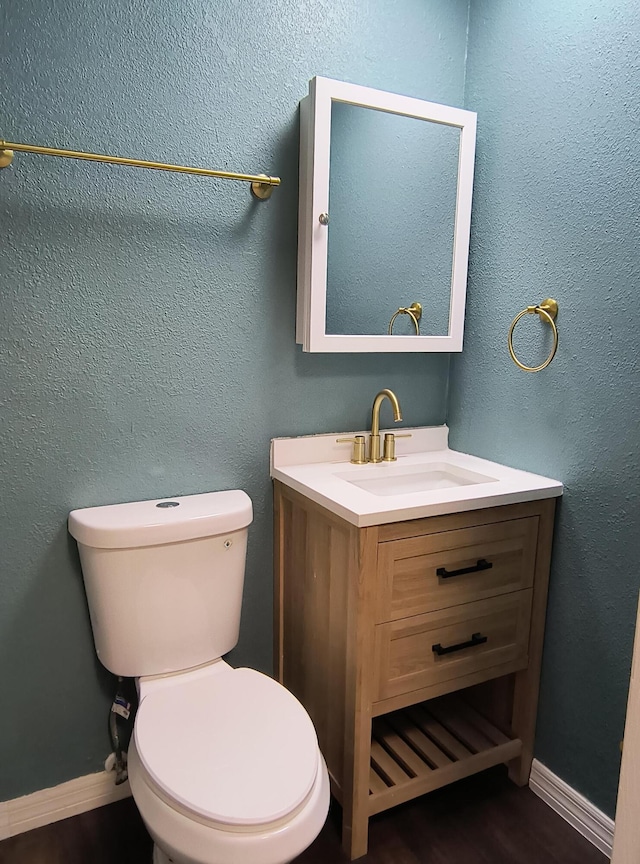 626 Texas Ct, Fort Pierce, FL 34950 - half bathroom with vanity, toilet, baseboards, and wood finished floors