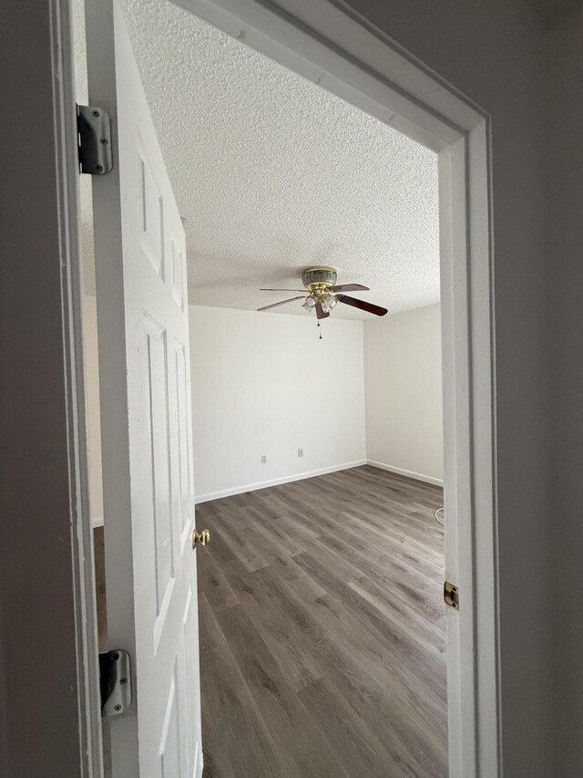614 SW Jeanne St, Port Saint Lucie, FL 34953 - unfurnished room featuring a textured ceiling, ceiling fan, dark wood-type flooring, and baseboards