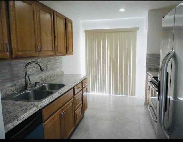 614 SW Jeanne St, Port Saint Lucie, FL 34953 - kitchen featuring stainless steel fridge with ice dispenser, dishwasher, a sink, tasteful backsplash, and brown cabinetry