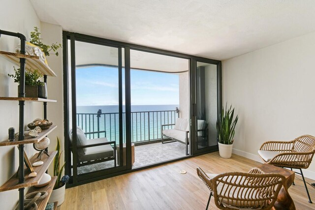 9650 S Ocean Dr Unit 1604, Jensen Beach, FL 34957 - living area featuring a water view, expansive windows, wood finished floors, and baseboards