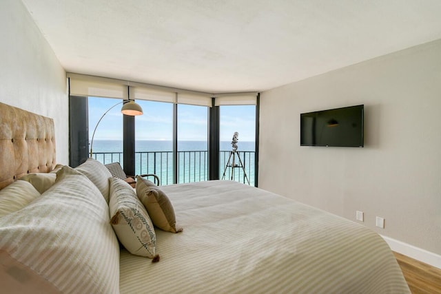 9650 S Ocean Dr Unit 1604, Jensen Beach, FL 34957 - bedroom featuring access to outside, wood finished floors, expansive windows, and baseboards