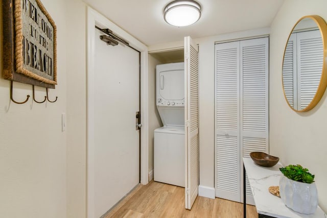 9650 S Ocean Dr Unit 1604, Jensen Beach, FL 34957 - washroom with stacked washer / dryer, light wood-type flooring, and baseboards