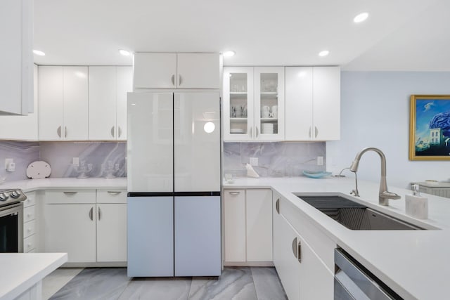 12 Royal Palm Way Unit 605, Boca Raton, FL 33432 - kitchen with stainless steel appliances, a sink, light countertops, backsplash, and white cabinetry