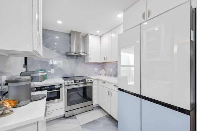 12 Royal Palm Way Unit 605, Boca Raton, FL 33432 - kitchen with wall chimney exhaust hood, stainless steel range with electric cooktop, freestanding refrigerator, and white cabinets