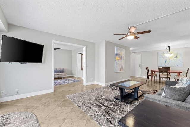 4511 S Ocean Blvd Unit 106, Highland Beach, FL 33487 - living area featuring a ceiling fan, baseboards, a textured ceiling, and tile patterned flooring